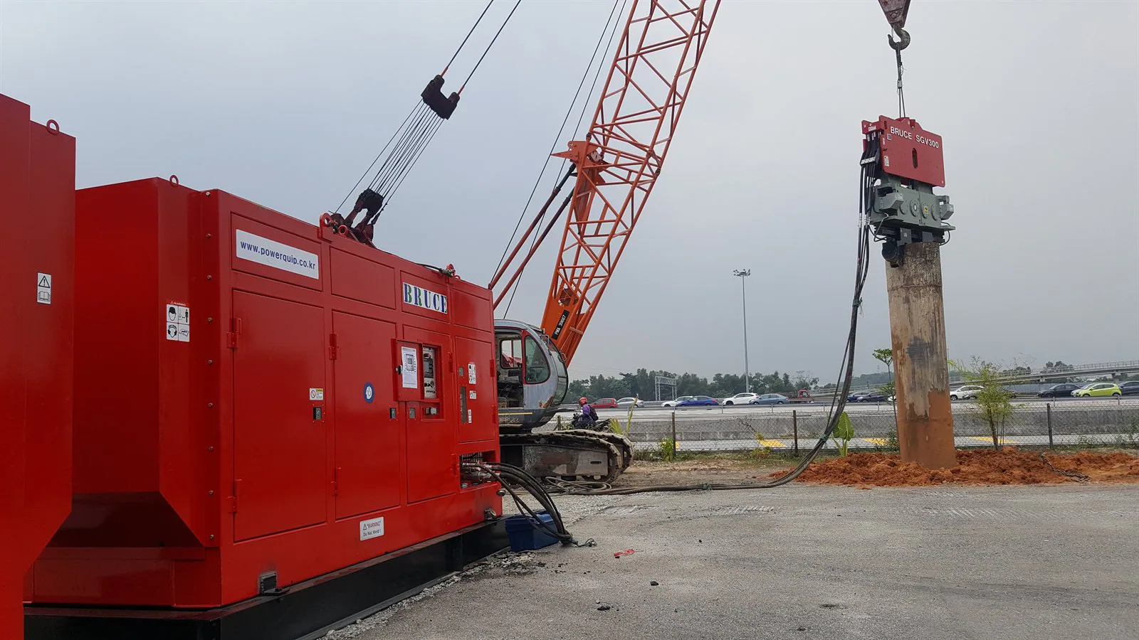 BRUCE SGV300 vibratory hammer at a worksite with power pack, crawler crane, steel pile and hydraulic hoses