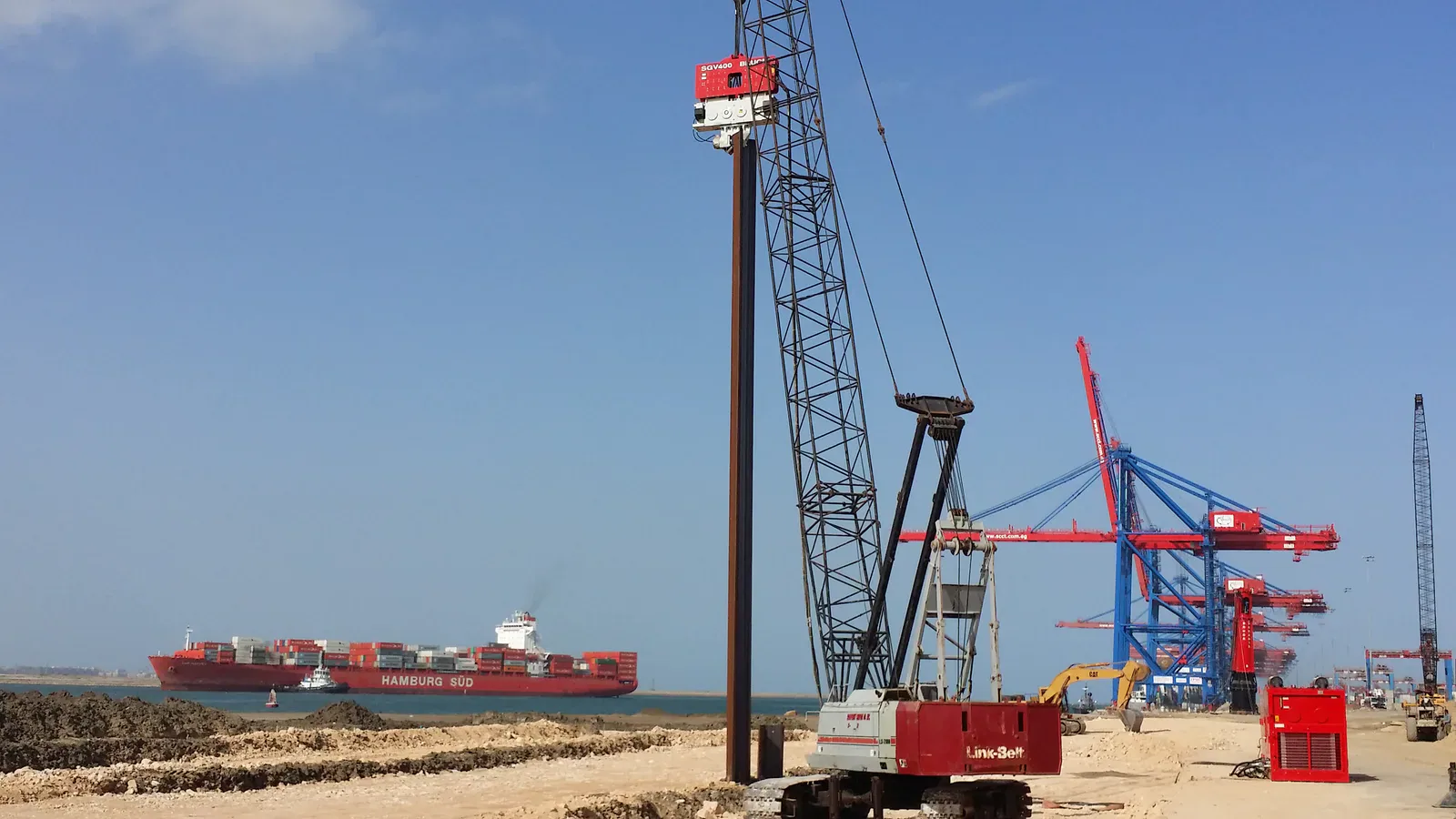 BRUCE SGV400 vibratory hammer on a steel pile at a waterfront site, with crawler crane and hydraulic power pack